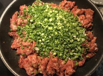 step5: 放入梅花肉拌炒到半熟，關火倒入蔥綠拌勻即可；