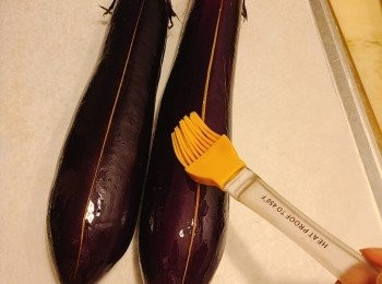 step2: 茄子原條洗淨抺乾，, 放上焗盤，中間切一刀不要切到底，原條塗上油。