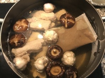 step3: 湯鍋中裝入足量的清水；倒入香菇和香菇水，放入洗淨的排骨和蒜頭；