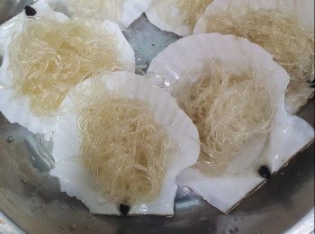 step1: 扇貝買回家清洗乾淨，將扇貝取出清洗殼，將粉絲用水浸軟，用雞湯撈勻加適量鹽，放入鑊中蒸3分鐘，除出放入扇貝殻上，取出鋪上扇貝開邊