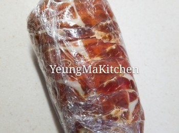 step9: 將保鮮紙從底向上捲，讓火腿完全包裹住牛柳的表面。在捲起保鮮紙時，要輕輕用力把肉卷捲得緊實。捲好牛肉後，再將左右兩端的保鮮紙扭緊。包好之後放入雪櫃15分鐘定型。