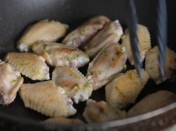 step2: 熱油鍋，將醃製好的雞翅下鍋煎至表面金黃後，加入醬油、砂糖並炒至上色。