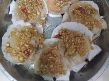 step2: 蒜蓉除一半放入鍋中爆香加入辣椒，取出倒落另一半蒜蓉加入適量鹽和糖攪勻,加上扇貝上邊，放入蒸籠上蒸5至6分鐘，取出加入蔥花