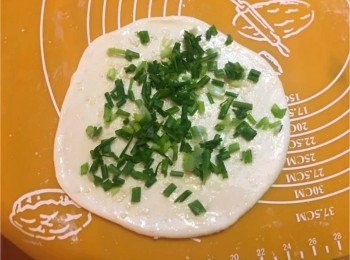 step3: 取出麵團之後，在桌面加上少許粉將麵團重複搓至數次，然後將麵團搓成長形切成四個小等份。
壓平，在餅皮上抹油、鹽、鋪上蔥。