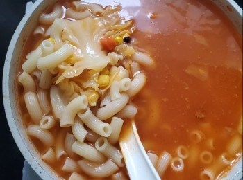 step2: 椰菜切片放入羅宋湯裏面煮3分鐘，加入少量粟米粒一同煮，加入通粉煮滾兜起，雞蛋各一隻，火腿片各一片放入碗中， 羅宋湯雞蛋火腿通完成