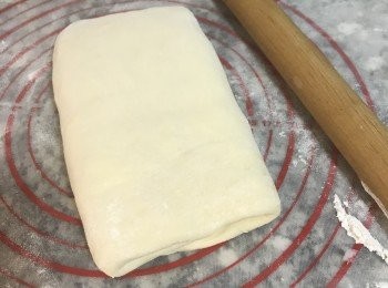 step11: 再取出，工作檯和麵皮上都撒些手粉，邊壓邊桿開後，再摺三摺；總共重覆摺4次。