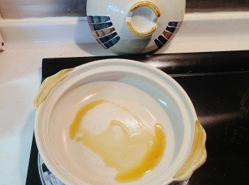 step8: 同時間先將砂鍋烘熱，再加入約一湯匙的黑麻油。(增添香氣)