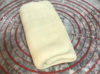 step10: 趁奶油未溶化前，用桿麵棍邊壓邊桿的將麵皮桿開，並摺成三摺，保鮮膜包起來，放冰箱冷藏30分鐘；