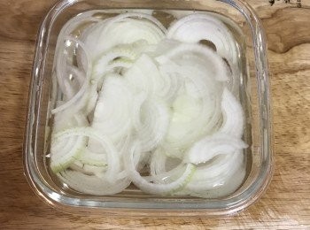 step2: 洋蔥去頭尾後對切，再切薄片後，泡入冰開水中以除去辛辣味；