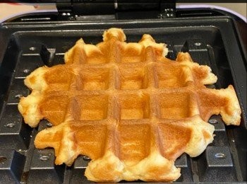 step5: 將麵團分成8份，成小球狀(每份約60g)，預熱窩夫機，掃上牛油，放入小圓球，烘約8分鐘，即成。(注：烘好的窩夫放在鐵架上放涼。)