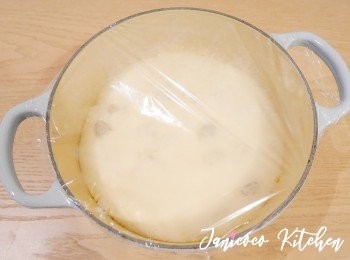 step3: 撒麵粉在麵團上取出麵團放在鑄鐵鍋內，並加上保鮮紙。