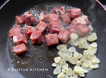 step2: 燒熱油，倒入牛柳粒大火煎至半熟時，倒入蒜片同煎。