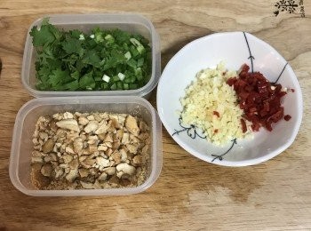 step11: 蔥切成蔥花，香菜略切；蒜拍扁去皮切末；辣椒去籽切丁；熟腰果或花生狀到保鮮袋裡，上面蓋塊乾布用打肉棍或橄麵棍略敲碎；