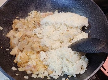 step5: 待雞肉炒至八至九成熟，跟著調最小火，加入冷飯(依舊細火)，撥散並慢慢炒勻，用鏟背一邊按壓一邊炒飯粒，如是者炒至粒粒分明。　