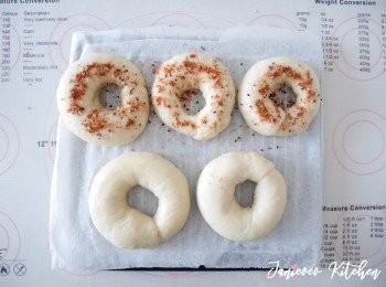 step9: 撈出貝果瀝乾，將貝果放在麵包紙上。所有貝果燙完糖水後，可以加蒜味<span class="group_2">調味粉</span>幫原味貝果上色。