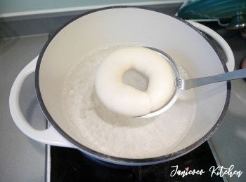 step8: 準備麵包紙鋪在烤盤上。另外焗爐200度預熱。糖水煮滾後轉小火，將貝果輕輕放入，面向下，底向上，燙20秒，再反轉將底燙20秒。喜歡嚼勁強硬可以分別燙30-40秒。