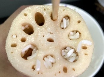 step2: 用刀在藕的一頭連同藕蒂切開，留作蓋子。將已經泡好的糯米填入蓮藕中，一邊填，一邊用筷子捅結實一點。