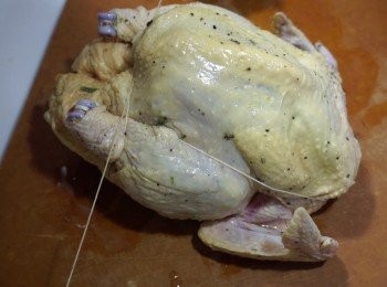 step5: 預熱焗爐200度
將榨汁後的檸檬、原條迷迭香及原粒蒜頭塞入醃好的雞隻
再用棉繩綁緊雞身
焗盤放上蒸架，再放上雞，先入爐焗20分鐘