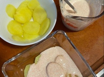 step3: 把軟淋的薯仔片舖在焗盤中，一層薯片一層明太子忌廉汁，重覆至舖完所有材料，最後灑上芝士碎。