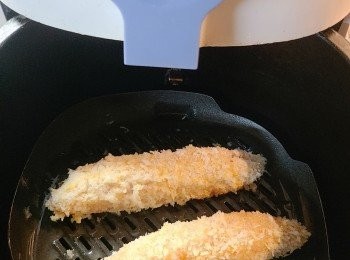 step5: 氣炸鍋180度，放入雞條並噴上少許油，氣炸約15分鐘（中途抽出來翻面及再噴油）炸至金黃脆身。(氣炸時間要視乎雞肉條大小，請自行調較。）。最後將炸好的雞肉條先放涼一下，再斜切成適合入口的大小，一口一個剛剛好，伴上小蕃茄和椰菜絲便可上碟。