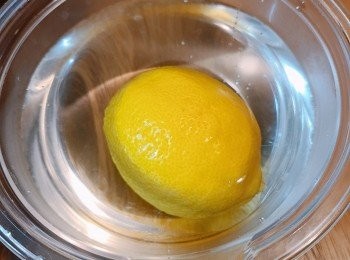 step2: 檸檬放在四十度左右的溫水中，用百潔布或者毛巾輕輕擦洗即可去除果蠟。
或擠一點牙膏，然後將牙膏溶解在水中，然後再用牙膏水清洗水果即可清除水果表面的果蠟。之後切片備用。