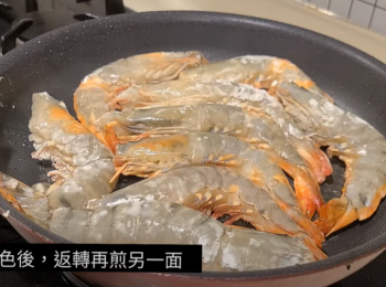 step2: 開火燒鑊下油。
虎蝦抹乾身，略上生粉，下鑊煎。
底部轉色後，反轉再煎。