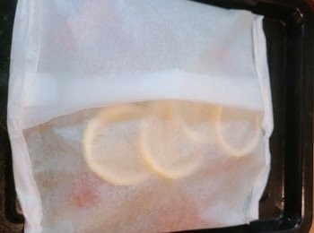 step4: 牛油紙向中間對摺後再向內摺實，左右兩邊向內摺封實邊位。將用牛油紙包好的魚放上焗盤，預熱焗爐180度，放進焗爐焗大約15分鐘或至魚熟透。