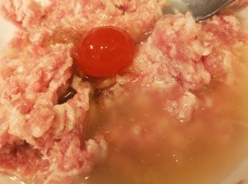 step2: 除放面咸蛋黃、粟粉和水備用，所有材料混合，其中一隻咸蛋黃壓碎混合，順時針攪拌，加入粟粉攪拌，加入2湯匙水再攪拌，直至帶有膠質，再將餘下的咸蛋放面，肉餅不要壓實，用筷子鬆一鬆開肉餅