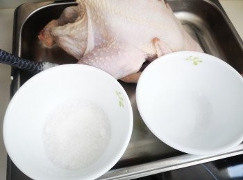 step2: 用米酒和鹽抹勻全身雞皮和內腔，薑片放入雞腔內