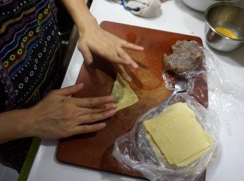 step8: 每張雲吞皮包入一小匙蝦膠，用蛋黃汁黏邊，對角摺好