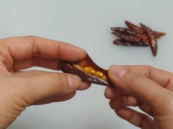 step5: 在辣椒乾的背部垂直劏開 **辣椒籽令湯汁香辣味更突出； 取出辣椒籽留烹調用