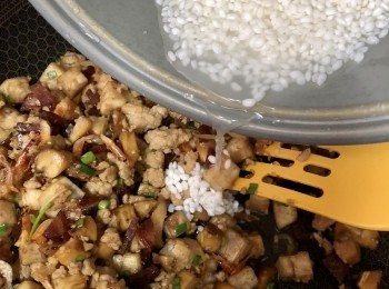 step9: 將浸泡好的米連水一併倒入已炒好的料內略為拌炒，然後放入飯煲內，按煮飯鍵煮熟。