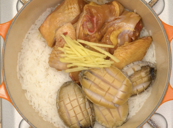 step4: 醃好的雞件、鮑魚及薑絲鋪在飯面上，加蓋細火煮8分鐘，加入大蝦轉中火加蓋煮30秒。 熄火焗15分鐘