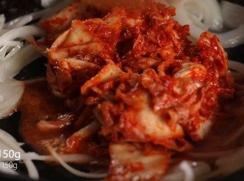 step2: 接著熱油鍋，將洋蔥、大蒜爆香後，加入泡菜拌炒。