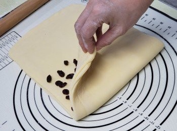 step8: 用棒輾成長方薄片，中間放一半葡萄乾，左邊摺上