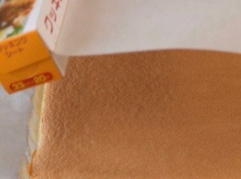 step11: 出爐後的蛋糕，進行脫模。
在表面先鋪上一張烘焙紙。
然後把蛋糕反轉