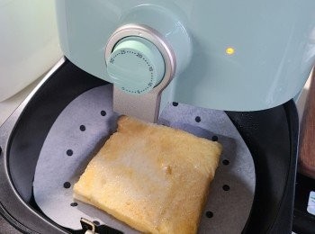 step5: 預熱氣炸鍋，放上一張baking paper，隨即放入方包，噴上少許油(會令其有脆炸口感效果)，再以180 度氣炸5分鐘便成。食時可加上一小片牛油和煉奶伴食。
