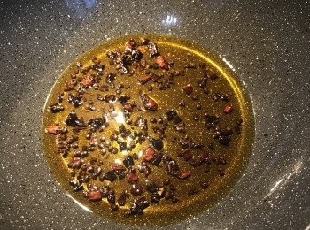 step12: 將花椒和剪過去籽的乾辣椒放入初榨橄欖油或耐熱油裡小火逼出香氣（不怕辣的話可以不去籽），然後再加入香油與辣油略煮，飄出香味後把乾辣椒和花椒用濾網撈掉不用。