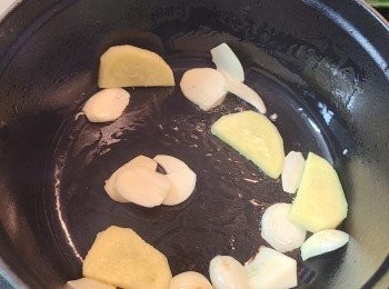 step3: 燒熱staub 鑄鐵鍋，下少許油先炒香薑片和蒜片。