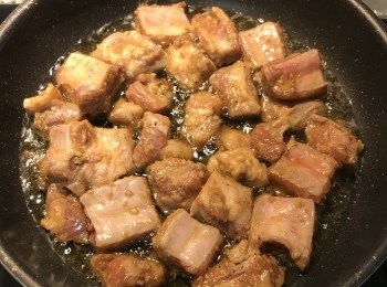 step4: 平底鍋放入比平時炒菜要多一點的油燒熱，放入排骨小火慢煎，煎到一面上色後翻面；