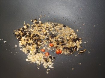 step2: 豆豉略沖洗再用水浸泡2分鐘，倒去水份;   易潔鑊燒熱2湯匙油， 下蒜蓉、浸泡過的豆豉及辣椒粒略爆，同時用鑊鏟把一半豆豉粒壓扁，撈起盛碗中