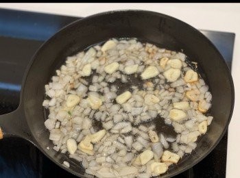 step3: 下油開鍋，中火燒至冒煙後轉小火，放入蒜片和洋蔥粒，炒至金黃色後撥去鍋邊