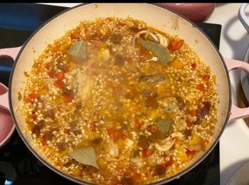 step10: 以畫圓圈分式均勻倒入約450ml 鮮魚高湯，灑上鹽、黑胡椒，加入月桂葉（湯面要浸沒米粒，不要再攪拌米飯，避免䆁出澱粉質變得濃稠）