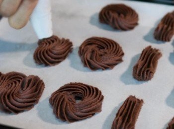 step7: 準備焗盤，鋪上牛油紙。
在紙上擠出自己喜歡的餅乾形狀。