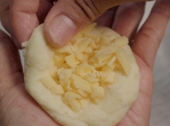 step3: 現在可以動手做薯仔芝士球了
拿起一點薯仔泥放在掌心
壓平然後放入一點芝士
把它包起來 就像做湯圓一樣
再輕柔地搓成圓球