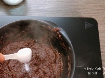 step4: 把紅豆蓉放入煎鍋，再加入油，用小火翻炒5分鍾，然後加入黑糖、蜜芽糖和鹽，不斷翻炒至溶解。