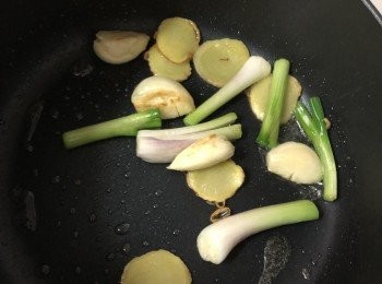 step8: 在鍋裡放油，爆香薑片、蒜頭及蔥白，然後夾起。
