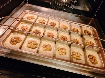 step10: 將蛋糕糊放入焗盆至九成滿並放上合桃粒，餘下的蛋糕糊可放入其他焗模或紙杯模一齊焗，再將焗盆拍幾下，拍出空氣；放入已預熱的焗爐，180度焗約半小時(牙籤插入蛋糕中心，拔出時乾淨即可。)