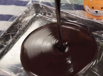 step5: 在模型上鋪上好保鮮紙
然後把朱古力倒進模型中

放進雪櫃裏至少1個小時。