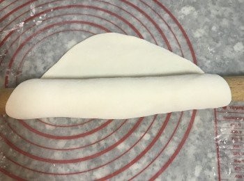 step7: 取一片麵皮，表面撒上手粉，用桿麵棍捲起來，並輕輕推滾；